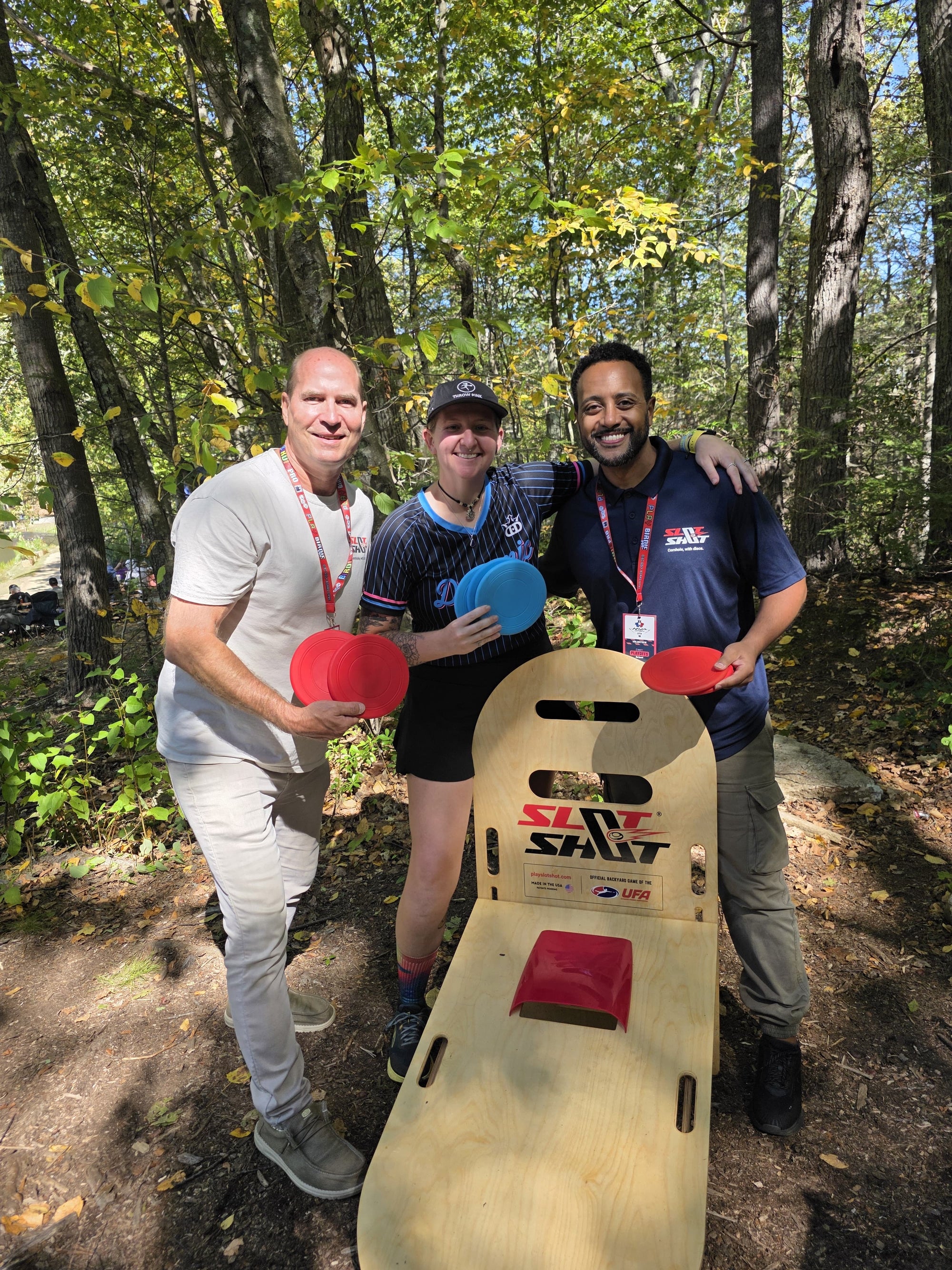 Disc golf pro Raven Klein and friends holding discs while playing SlotShot backyard game outdoors